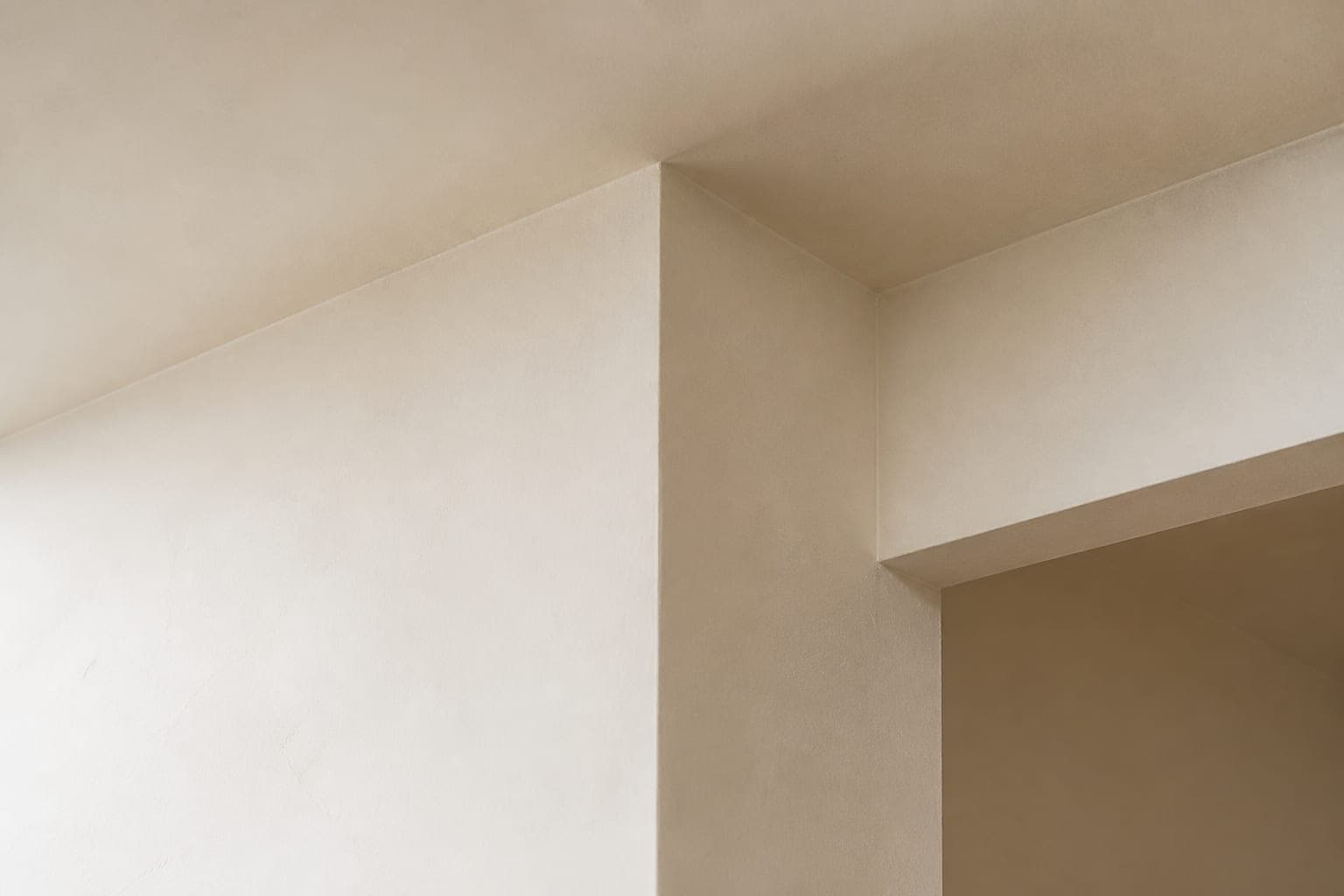 Detailfoto van een strak en vlak afgewerkte wand- en plafondhoek